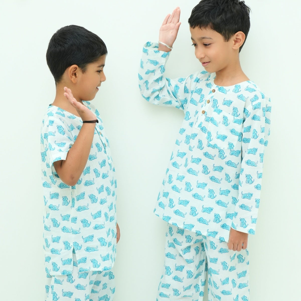 Good Doggo PJ set klephant night suit
Two children wearing matching pajamas with a blue animal pattern on a white background