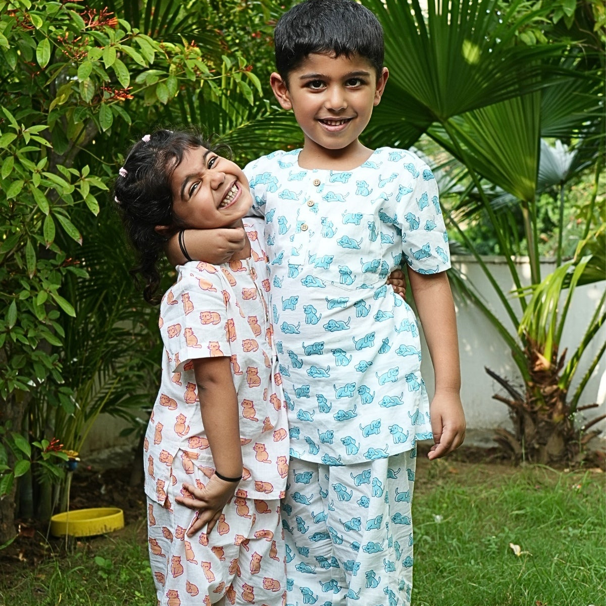 Good Doggo PJ set klephant night suit Two children in matching pajamas standing in a garden.