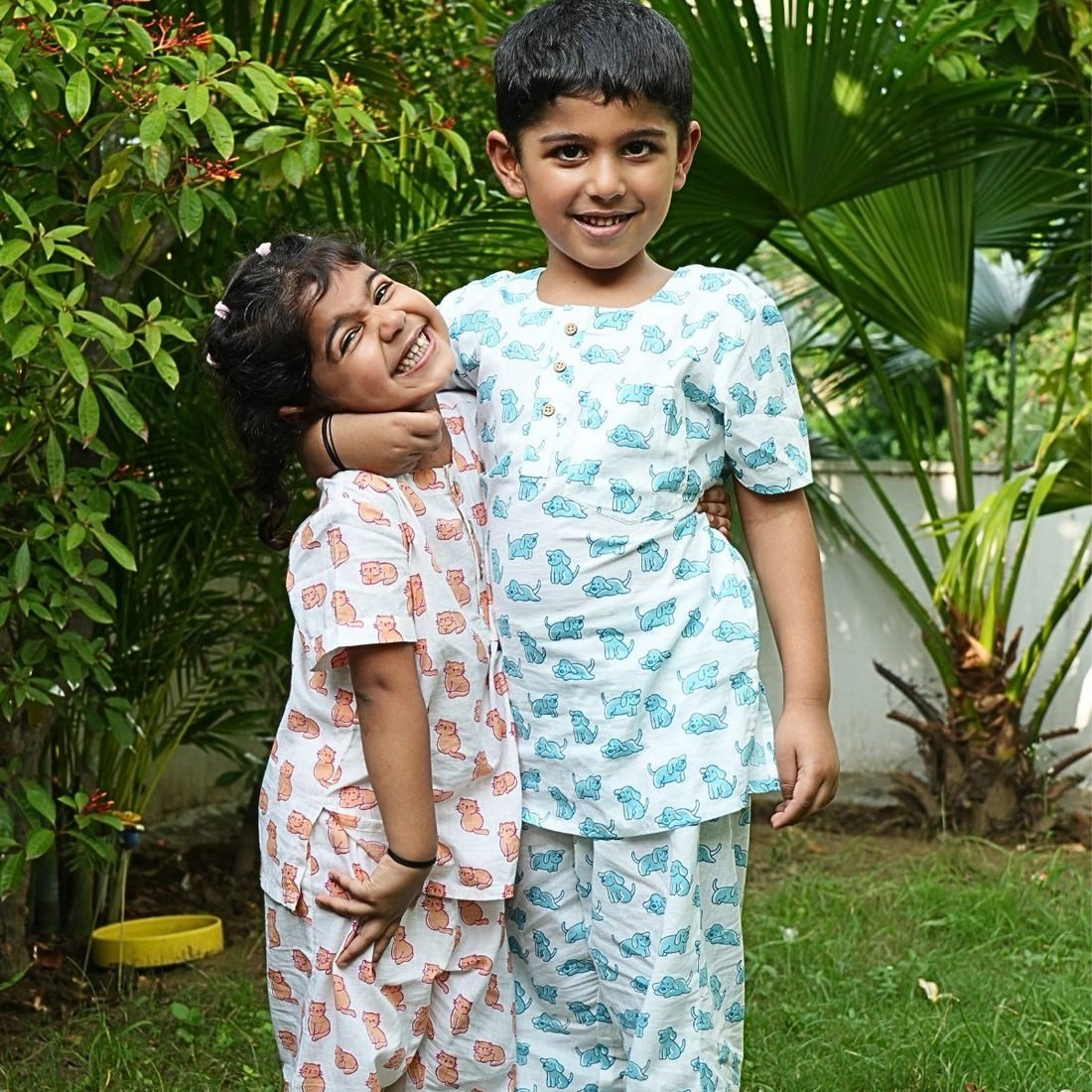 Good Doggo PJ set klephant night suit Two children in matching pajamas standing in a garden.