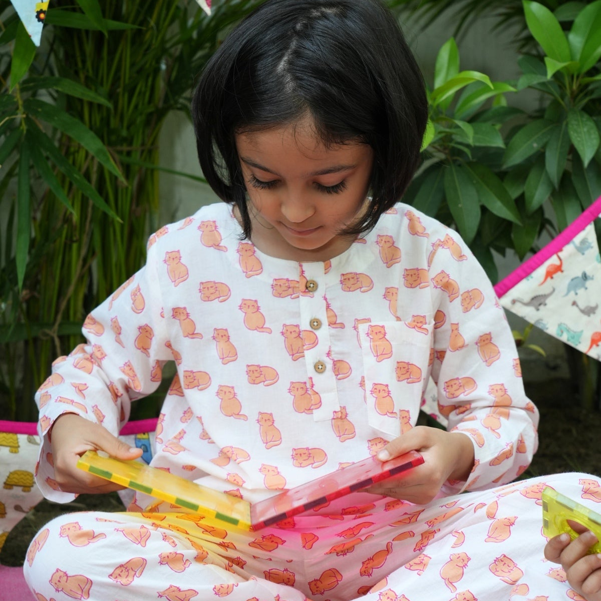 Meow Mornings PJ set night suit Child in pajamas playing with colorful toys outdoors