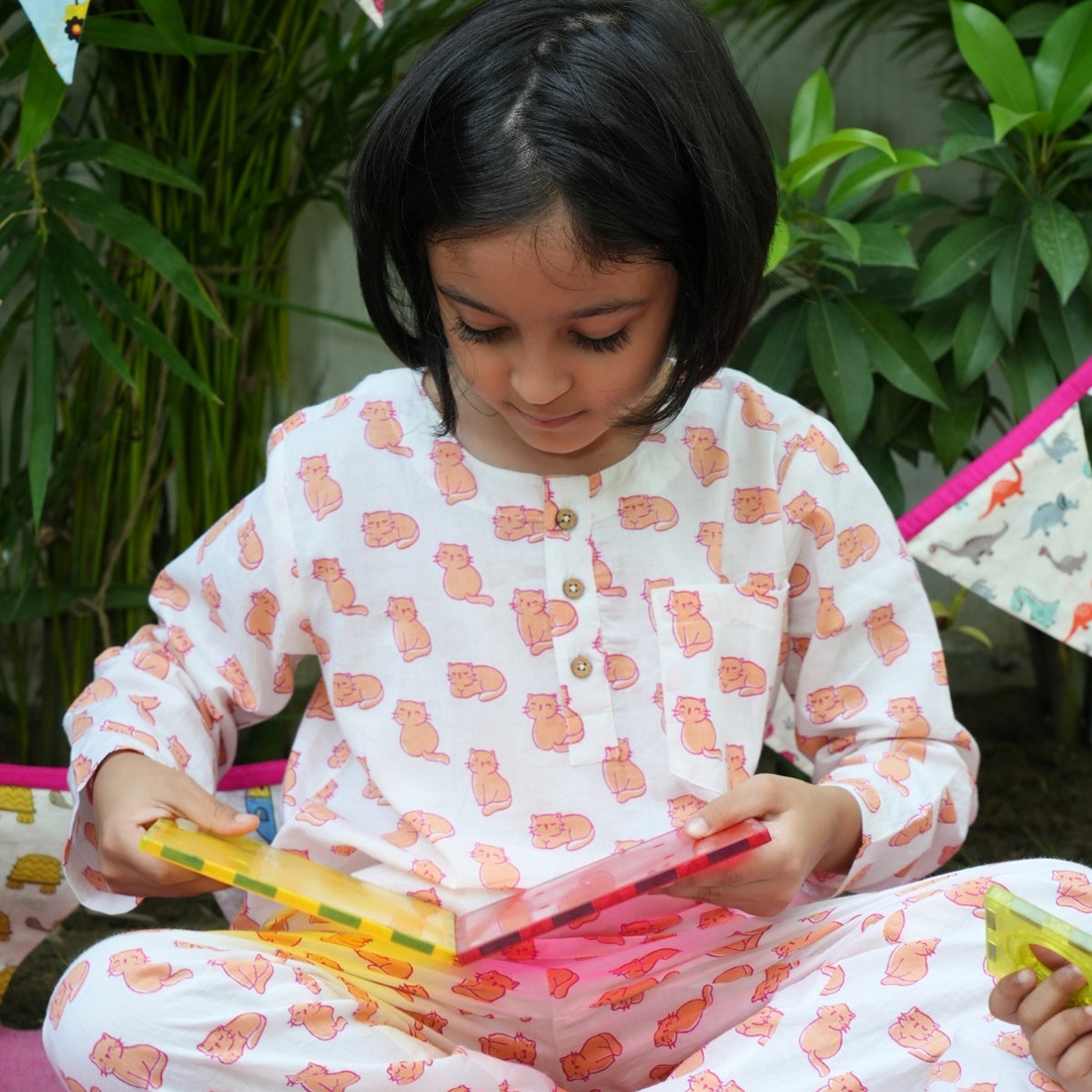 Meow Mornings PJ set night suit Child in pajamas playing with colorful toys outdoors