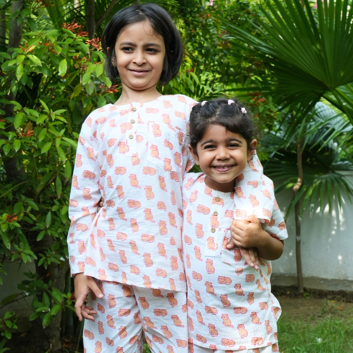 Meow Mornings PJ set night suit
Two children in matching pajama sets standing outdoors with greenery in the background